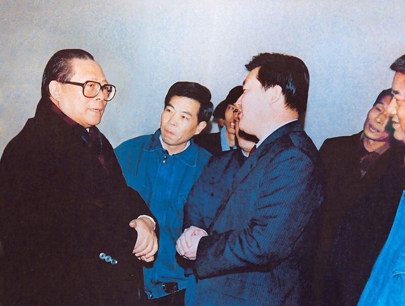 1991年2月5日，时任中共中央总书记的江 泽 民（左一）视察利来国际，他指示：“抓住机遇，深化改革，扩大开放，促进发展，保持稳定。”